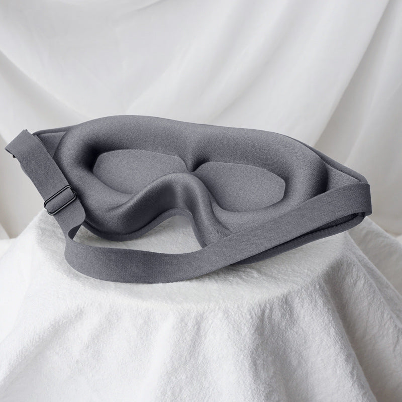Black, grey and blush DeepRest sleep masks arranged on white linen
