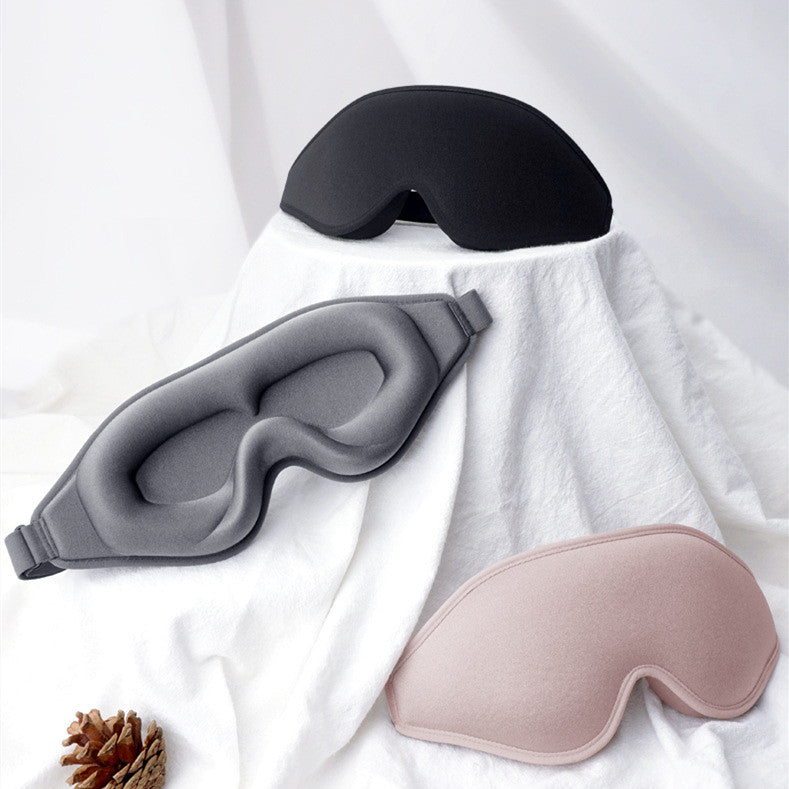 Nightfold DeepRest 3D contoured sleep mask in black, grey and blush on white bedding